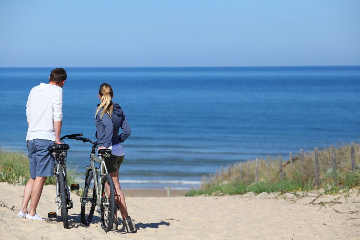 couple on bikes by beach