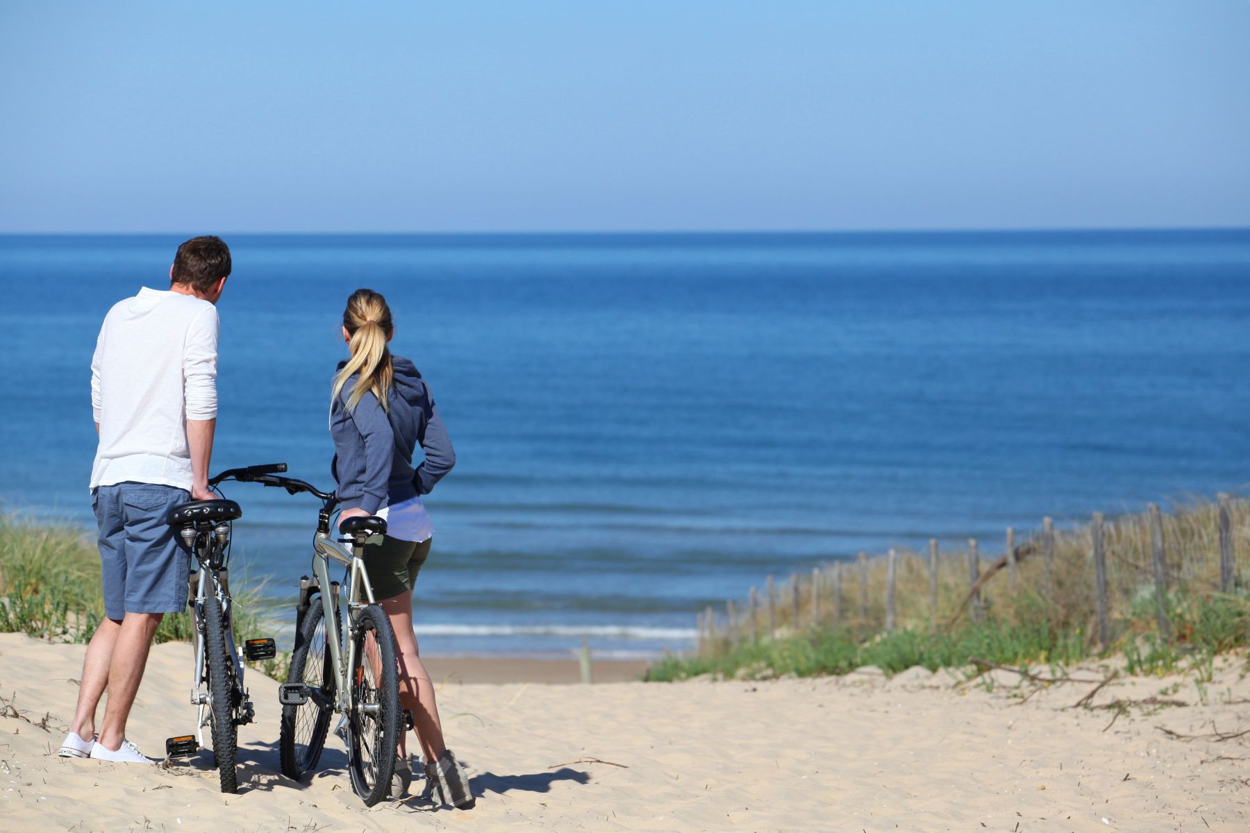 couple on bikes by beach